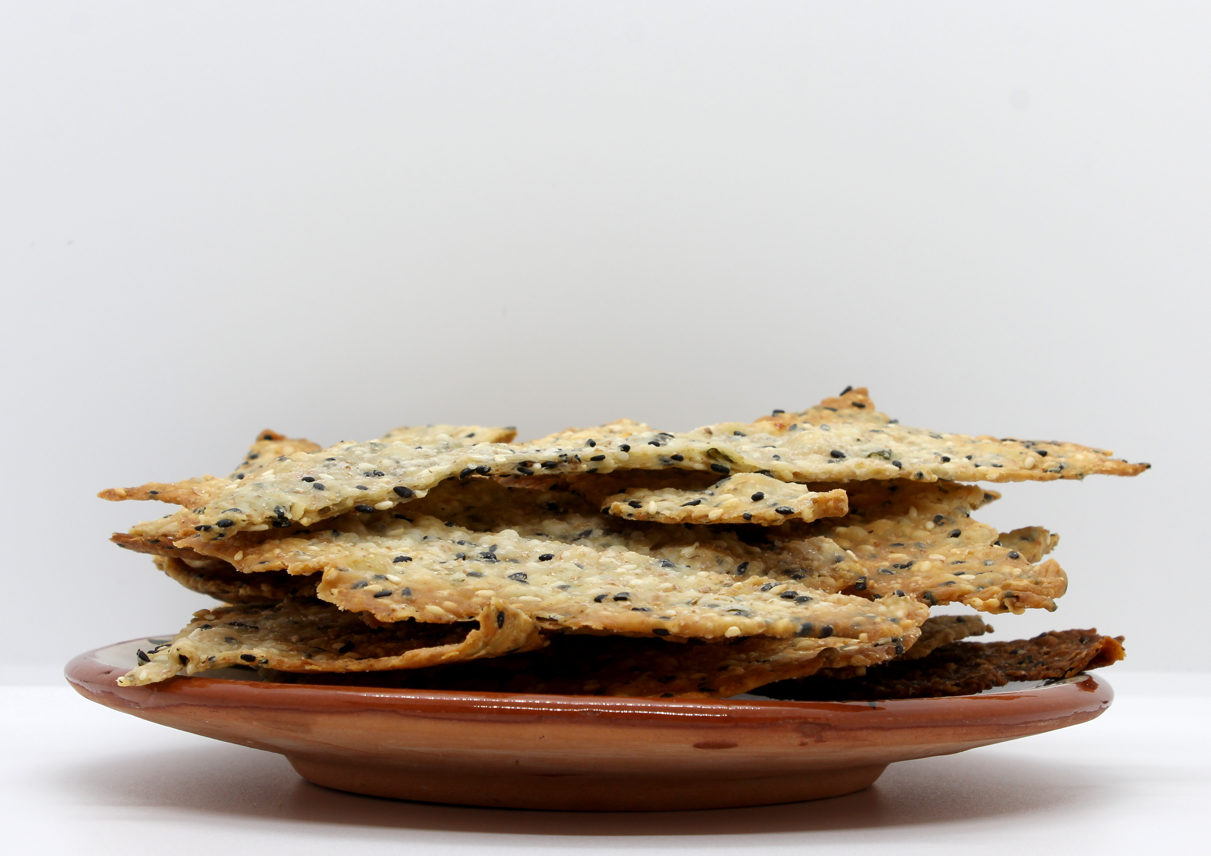 A plate of homemade sesame seed lavosh crackers piled on a plate and ready to eat..jpg